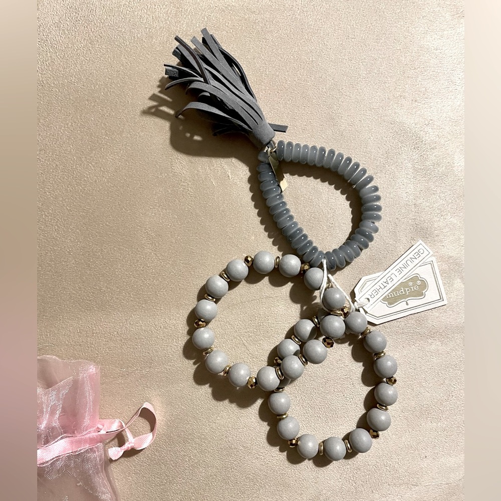 Gray bracelet trio with gold and leather details